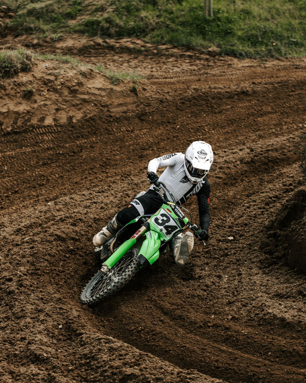 Rider railing a berm on a Kawasaki KX450, tire sidewall knobs doing the work